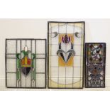 Three stained and leaded glass panels, early 20th century, to include an example with a shield