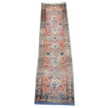 A Persian village wool runner, woven in blue and red dyes with a traditional trailing foliate