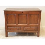 A George III oak mule chest, the hinged three plank top above three panels and two drawers, raised