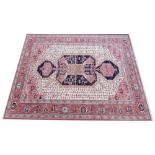 A modern Royal Kashan wool carpet, with a mirrored geometric design upon a pink and ivory ground,