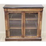 A Victorian rosewood pier cabinet, the rectangular moulded top above a pair of glazed doors