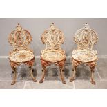 Three 19th century cast iron Coalbrookdale style garden/patio chairs, each with a leaf and