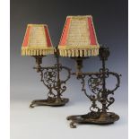A pair of wrought iron desk lamps in the Medieval manner, each with pierced supports and raised on a