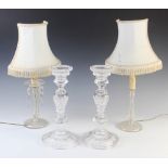 A pair of early 20th century glass candlesticks, with baluster columns raised upon a spreading