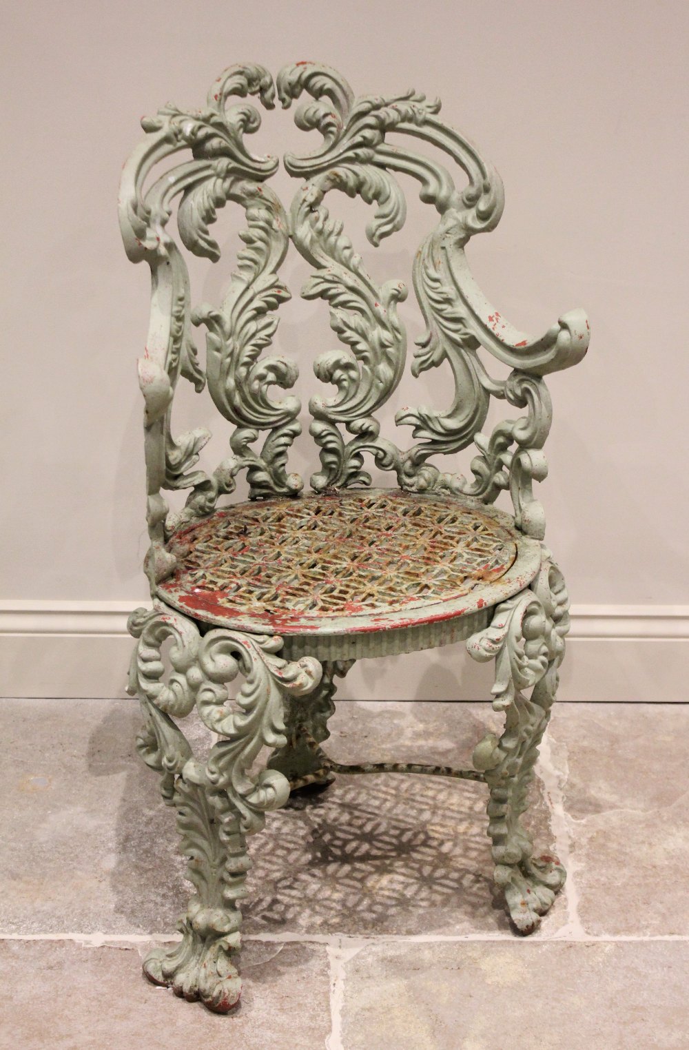 A 19th century cast iron garden/patio chair, with a scrolling leaf cast back rest extending to out