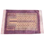 An Afghan Taimani prayer rug, woven in aubergine and buff dyes with a central spade shaped medallion