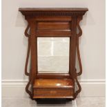 An Edwardian mahogany wall mirror, with a moulded pediment and dentil frieze over a bevelled glass