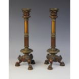 A pair of patinated bronze candlesticks in the manner of William Bullock, 20th century, the tri-form