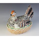 A Staffordshire novelty egg basket modelled as a hen, coloured in Pratt type colours, the lower