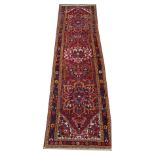 A Turkish wool runner, woven in red, yellow and blue dyes with three medallions surrounded by a