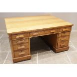 A mid century golden oak partners desk, the rectangular slab top above three frieze drawers, upon