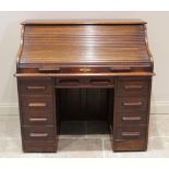 An early 20th century oak roll top desk, the tambour front opening to a compartmentalised interior