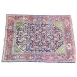 A Persian Village wool rug, the central panel with an abundance of repeating motifs, enclosed by