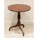 A George III mahogany tripod table, the circular tray top with a raised rim, upon a baluster and