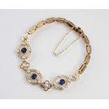 An Edwardian sapphire and cultured pearl set bracelet, comprising three pierced oval panels each set