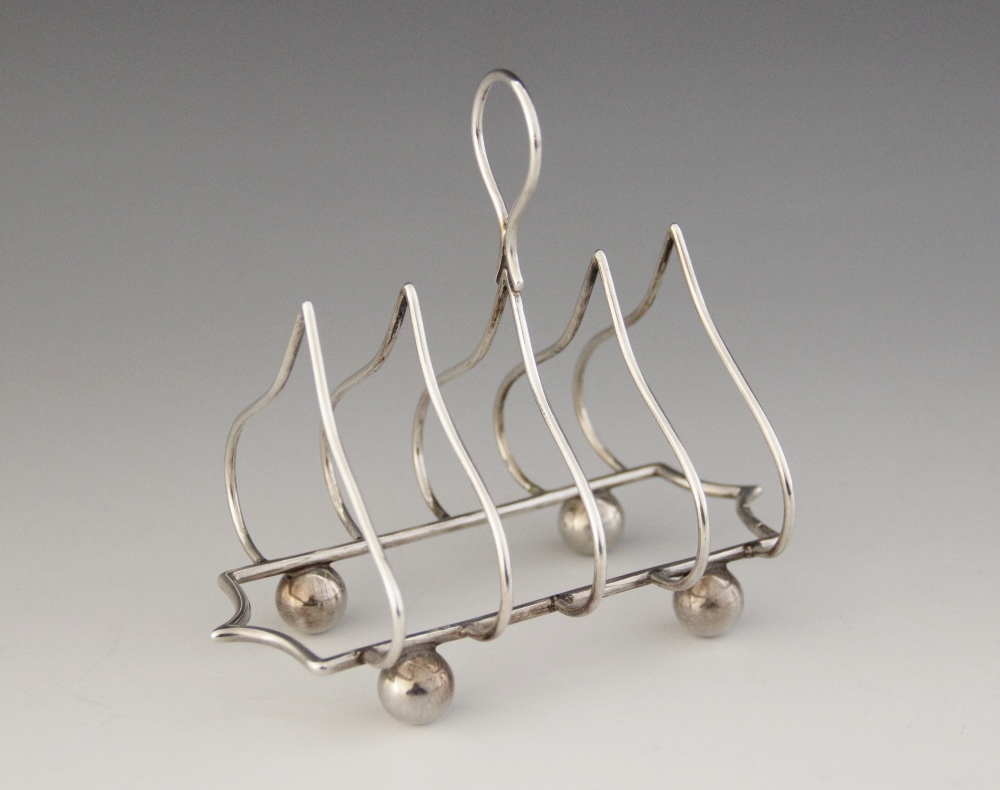 An Edwardian silver four division toast rack, Jones & Crompton, Chester 1906, ogee arches with - Image 2 of 6