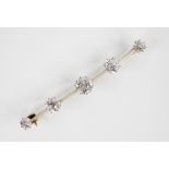 A diamond five stone brooch, the central old cut diamond weighing approximately 1 carat, with a