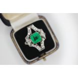 An Art Deco emerald and diamond ring, the central octagonal step cut emerald measuring 8.35mm x 8.