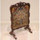 A French walnut fire screen, 19th century, the Rococo leaf swept carved frame enclosing a