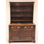 An early 18th century oak dresser, the high back with a moulded cornice above a lunette pierced