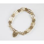 A 9ct gold gate and brick link bracelet, total length 19cm, suspending a 9ct gold heart shaped