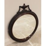 A Regency style circular wall mirror, early 20th century, the carved Adams style urn and swag