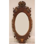 A 19th century mahogany oval wall mirror, the central mirror plate gilt bordered with carved foliate