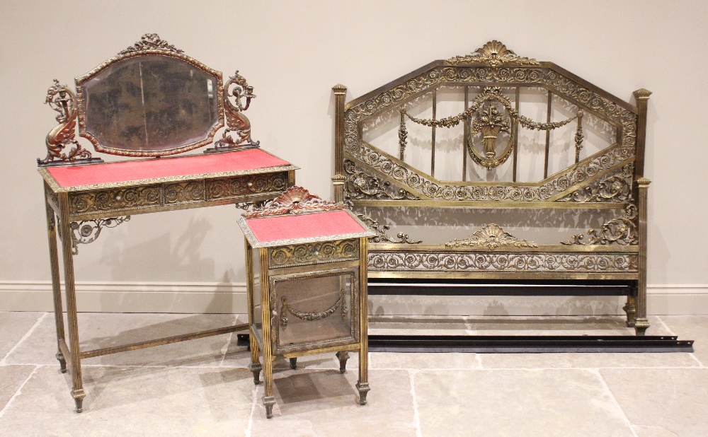 A French Belle Epoque brass three piece bedroom suite, comprising; a dressing table with a shaped