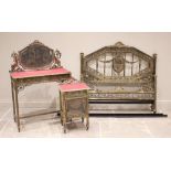 A French Belle Epoque brass three piece bedroom suite, comprising; a dressing table with a shaped