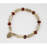 An amber set gate link bracelet, the gate link chain interspersed by seven amber oval cabochons,