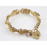 A yellow metal gate-link bracelet, length of bracelet 18.5cm, links unmarked, suspending a heart-