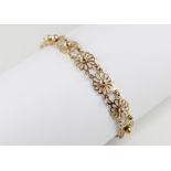 A 9ct gold floral design line bracelet, comprising eleven pierced design floral design links, each