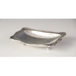 A George V silver pin dish, Omar Ramsden, London 1922, of rectangular form with shaped borders on