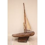 A late 19th/early 20th century pond yacht, with a natural wooden finish, the single mast with fabric