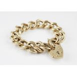 A 9ct gold curb link bracelet, length of chain approx. 20cm, suspending a 9ct gold heart shaped