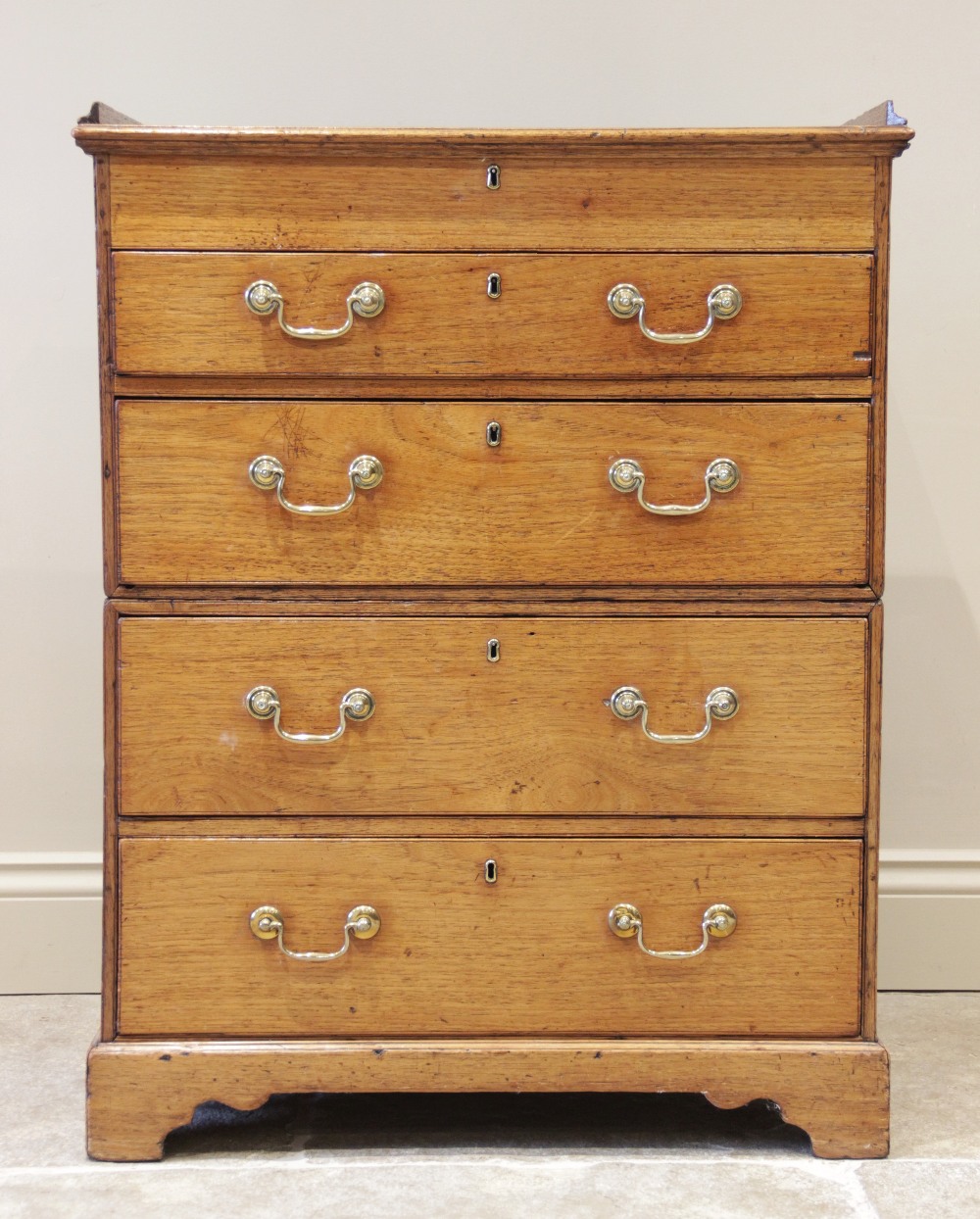 A late 19th century two section teak campaign chest, the hinged top with a three quarter gallery