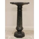 An Italian carved serpentine pedestal, 19th century, the fluted column below a square section plinth