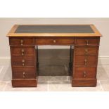 An Edwardian mahogany twin pedestal desk, the leather inset skiver above an arrangement of nine