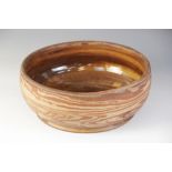 A terracotta studio pottery bowl of large proportions, the glazed interior with mottled ochre tones,