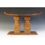 A West African Ghana Ashanti stool supported by two pillars, 37cm high x 53cm wide