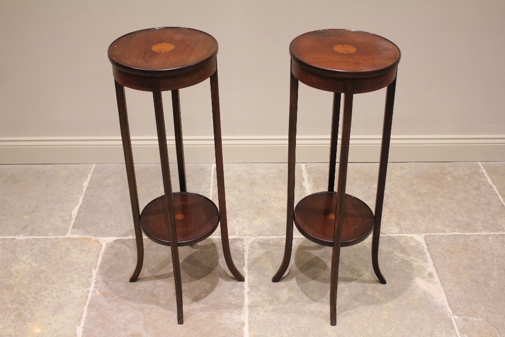 A pair of Edwardian mahogany and cross banded jardinière stands, each centred with an inlaid