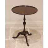 A George III style mahogany tripod table, early 20th century, the circular tray top upon a slender