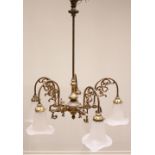 An early 20th century brass chandelier, the plain cylindrical support extending to a baluster shaped