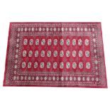 A Lahore Bokhara rug, the deep raspberry field with three columns of quartered gulls enclosed by