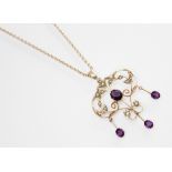 An Edwardian paste and seed pearl set pendant, the openwork scrolling pendant set with amethyst