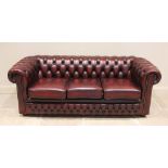 An oxblood red leather Chesterfield settee, late 20th/early 21st century, of typical deep set button