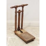 A late Victorian walnut freestanding boot jack, the turned handles upon a pair of octagonal uprights