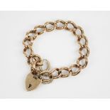 A 9ct gold curb link bracelet, suspending a 9ct gold heart-shaped padlock fastener, 18cm long,