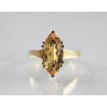 A topaz set 18ct gold ring, the marquise shaped golden coloured topaz measuring 15mm x 7mm, claw set