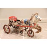 A 1930's Tri-ang tin plate pedal horse and cart, painted in red, white and blue colourways,